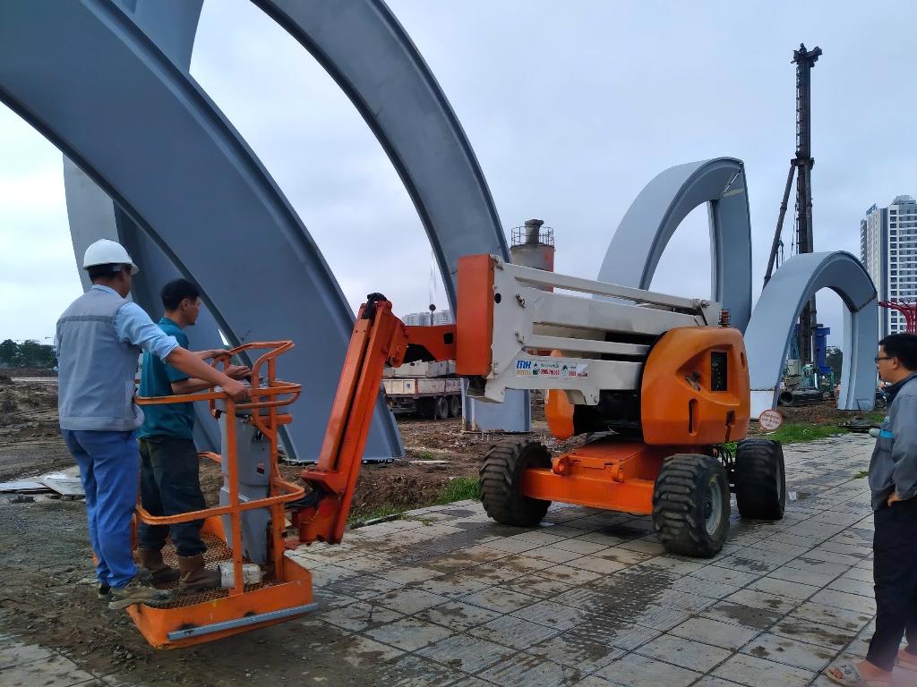 Xe nâng người màu cam bên khung thép tại khu vực Gia Lâm, Hà Nội