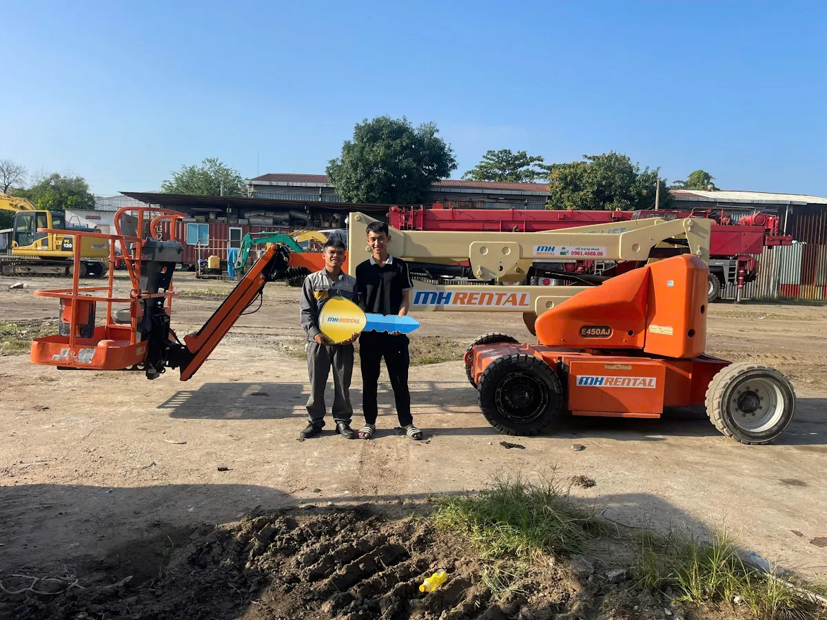 Hình ảnh trao chìa khóa tượng trưng bên xe JLG E450AJ bàn giao cho Mita tại Bình Dương