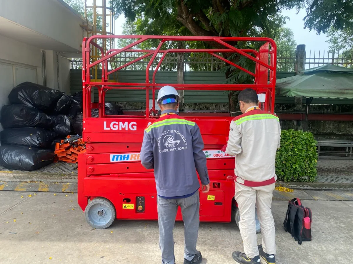 Những người tham gia bàn giao đứng cạnh xe LGMG AS0808 trong hồ sơ TNT Technology