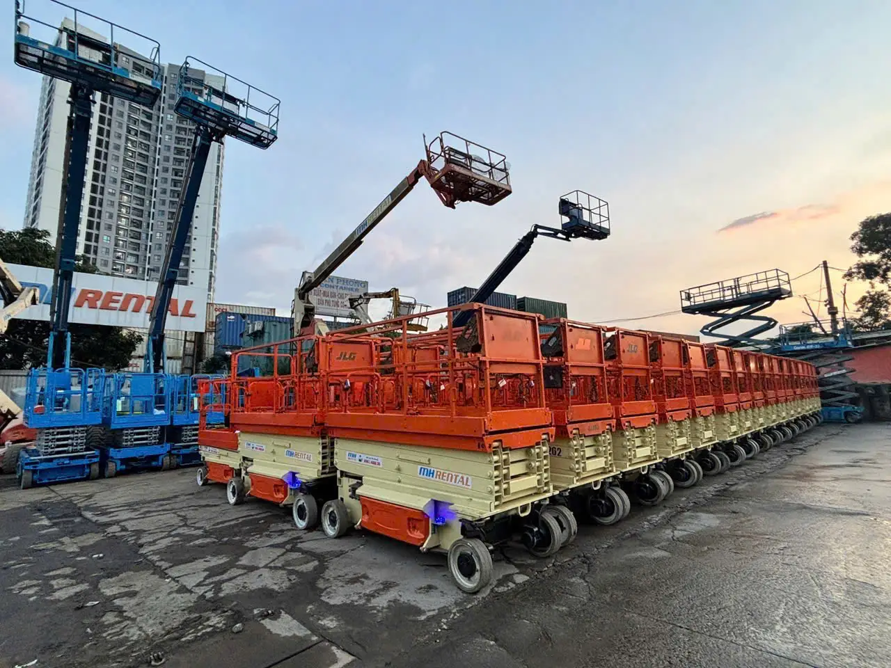 Dãy xe nâng người cắt kéo JLG mang nhận diện MH Rental tại bãi xe