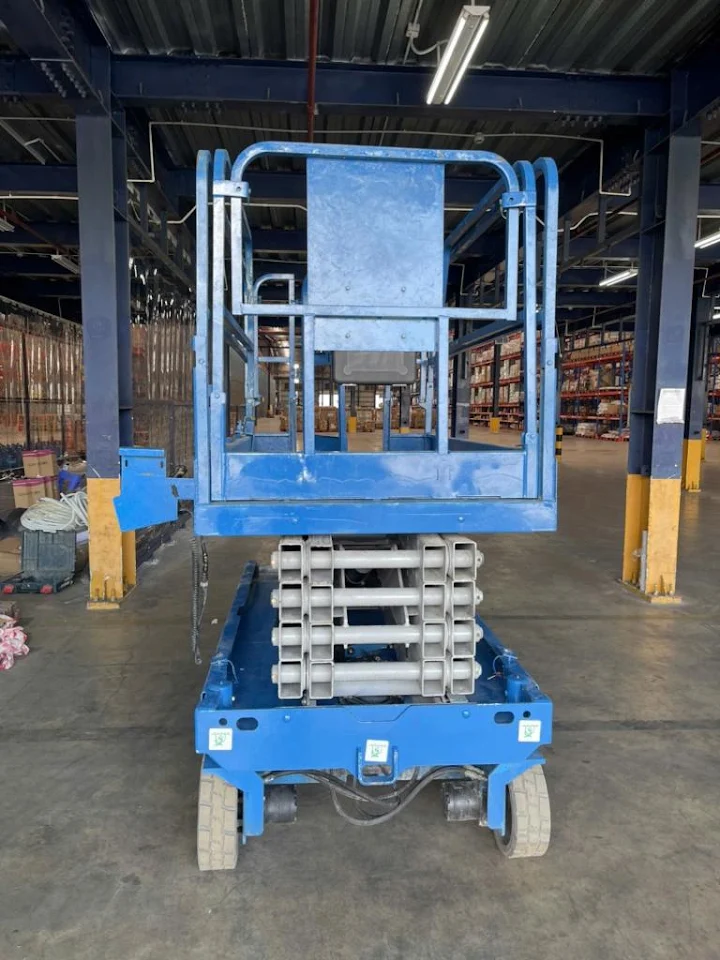 Góc trước xe Genie GS-3246 với sàn nâng đang được nâng lên trong nhà xưởng