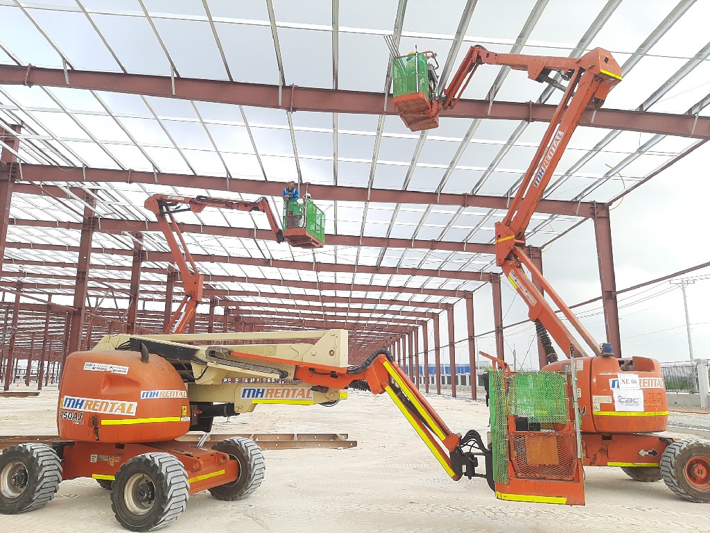 Xe nâng người dạng cần trong nhà xưởng.