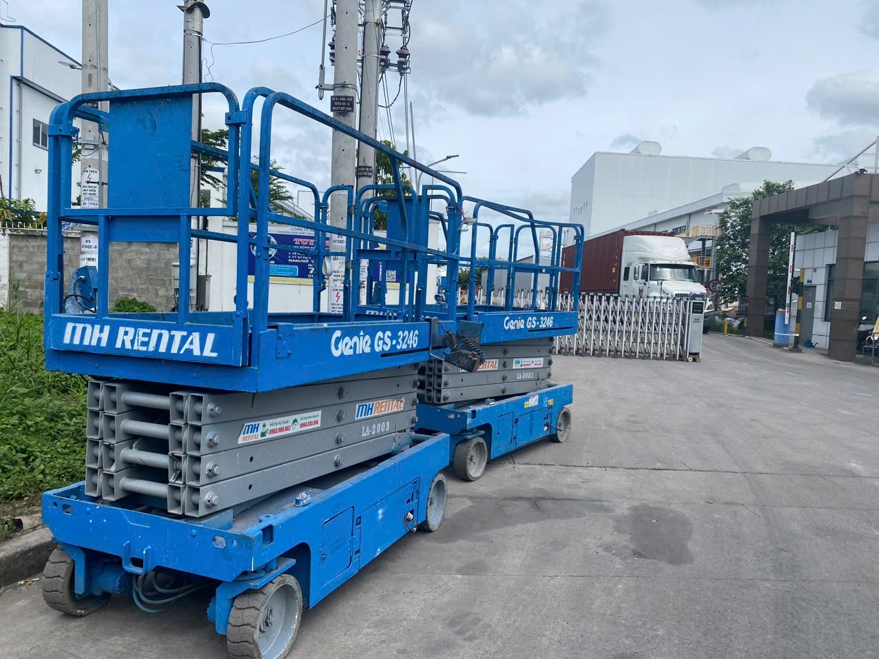 Hai xe cắt kéo màu xanh MH Rental tại cổng nhà máy Advance