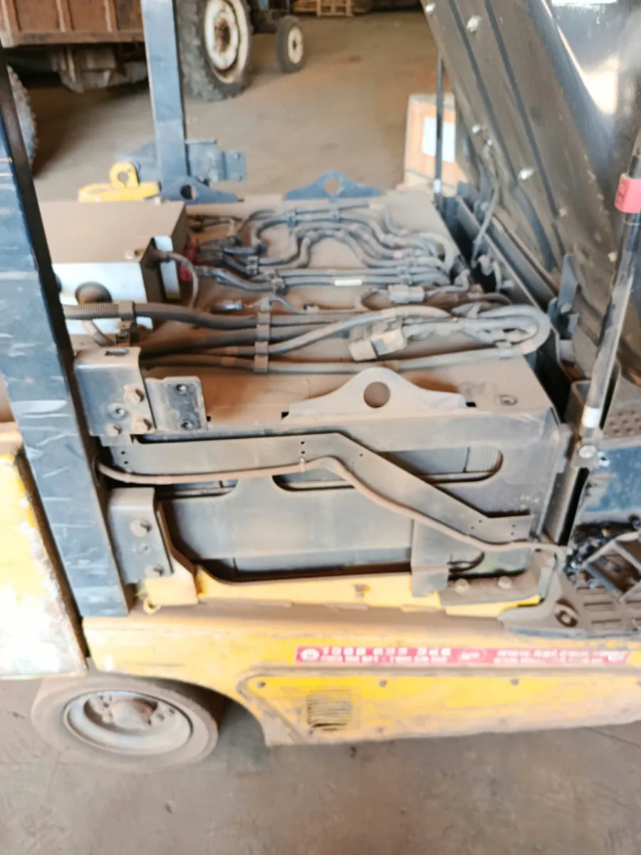 Ắc quy chì và dây cáp cũ trong khoang xe nâng trước khi thay pin lithium
